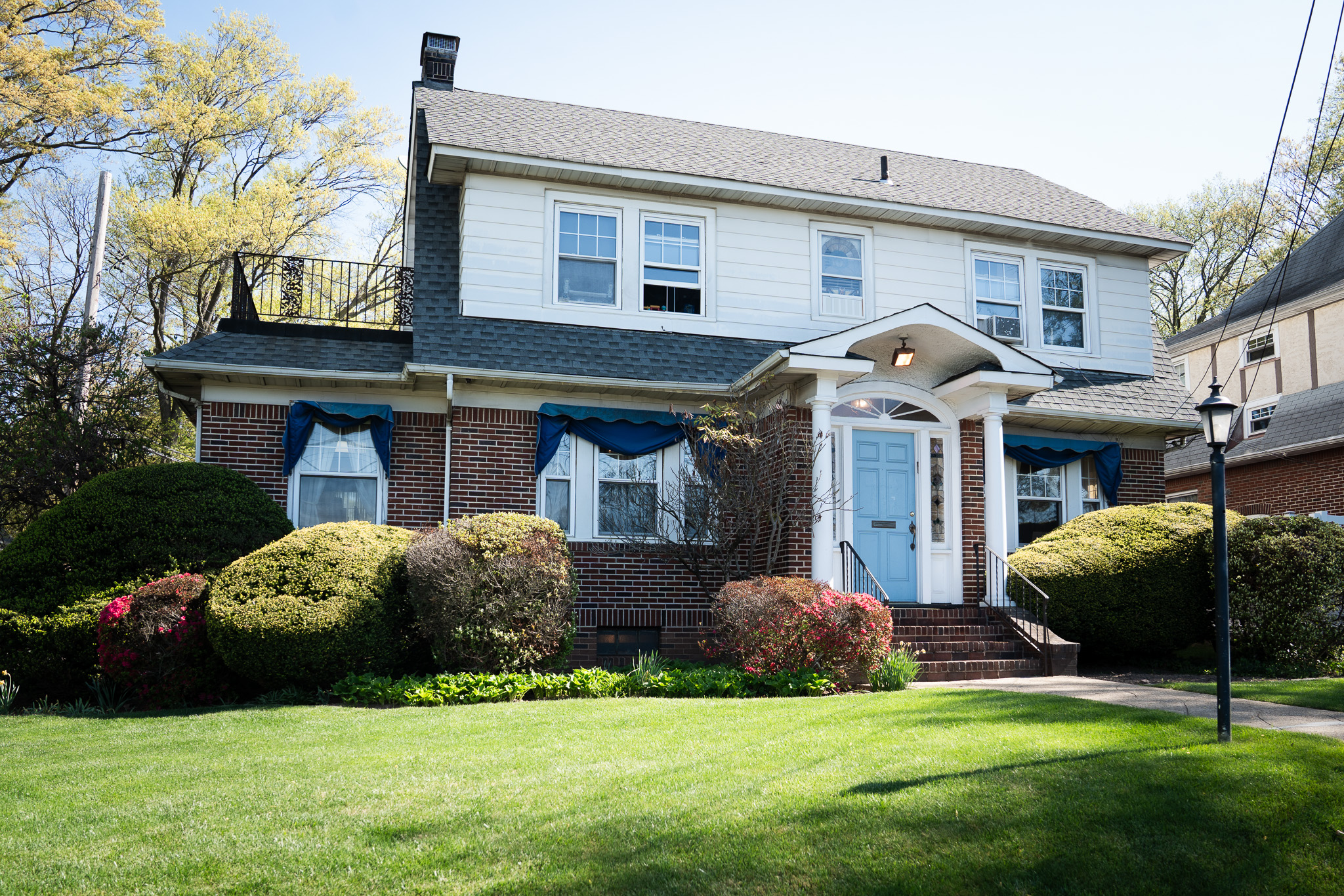 The Pieroni & Fiorello office — a brick colonial home on Clove Road with a blue front door